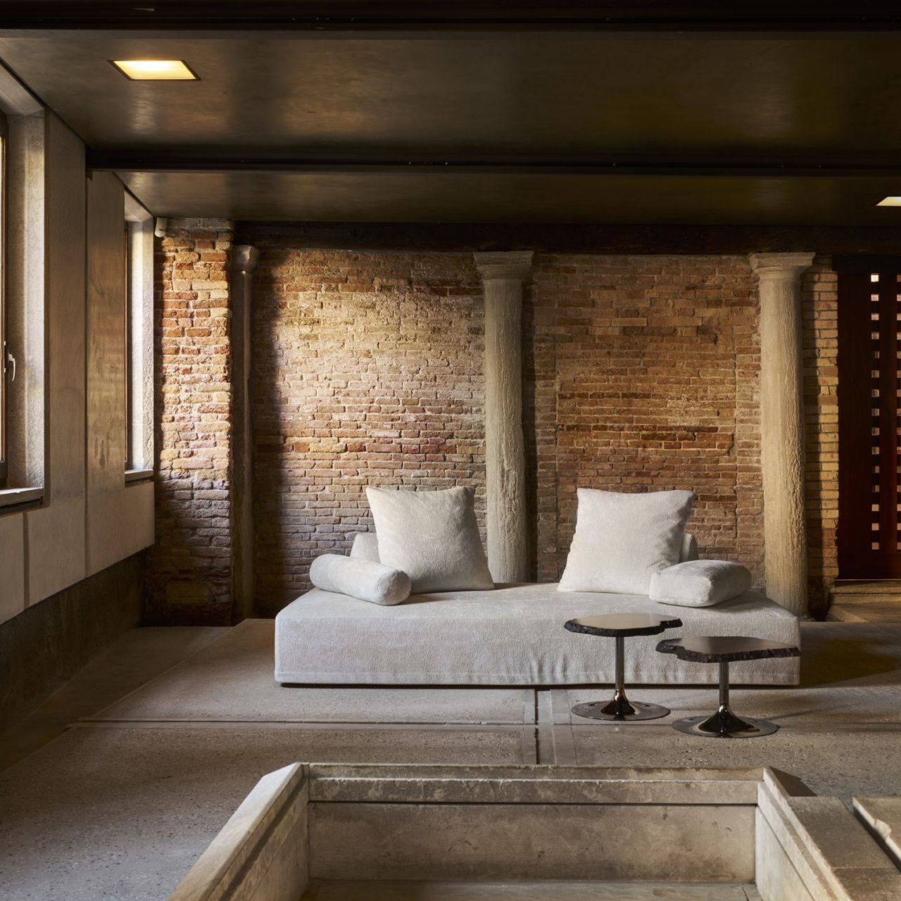  Sherazade und Cicladi. Das Sofa in sandfarbenem Gentle Cloud und die Tische aus bernsteinfarbenem Alabaster am Eingang zum Scarpa-Bereich. 