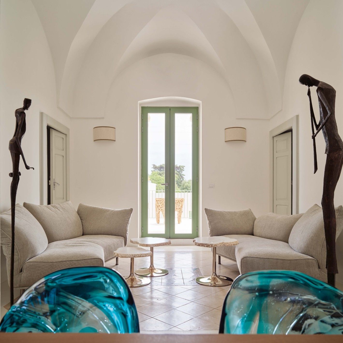  Standalto, Cicladi. Dans le s&eacute;jour, les formes douces des canap&eacute;s en Soft Imperial et des tables en alb&acirc;tre rappellent les courbes de l&rsquo;escalier de la fa&ccedil;ade. 
