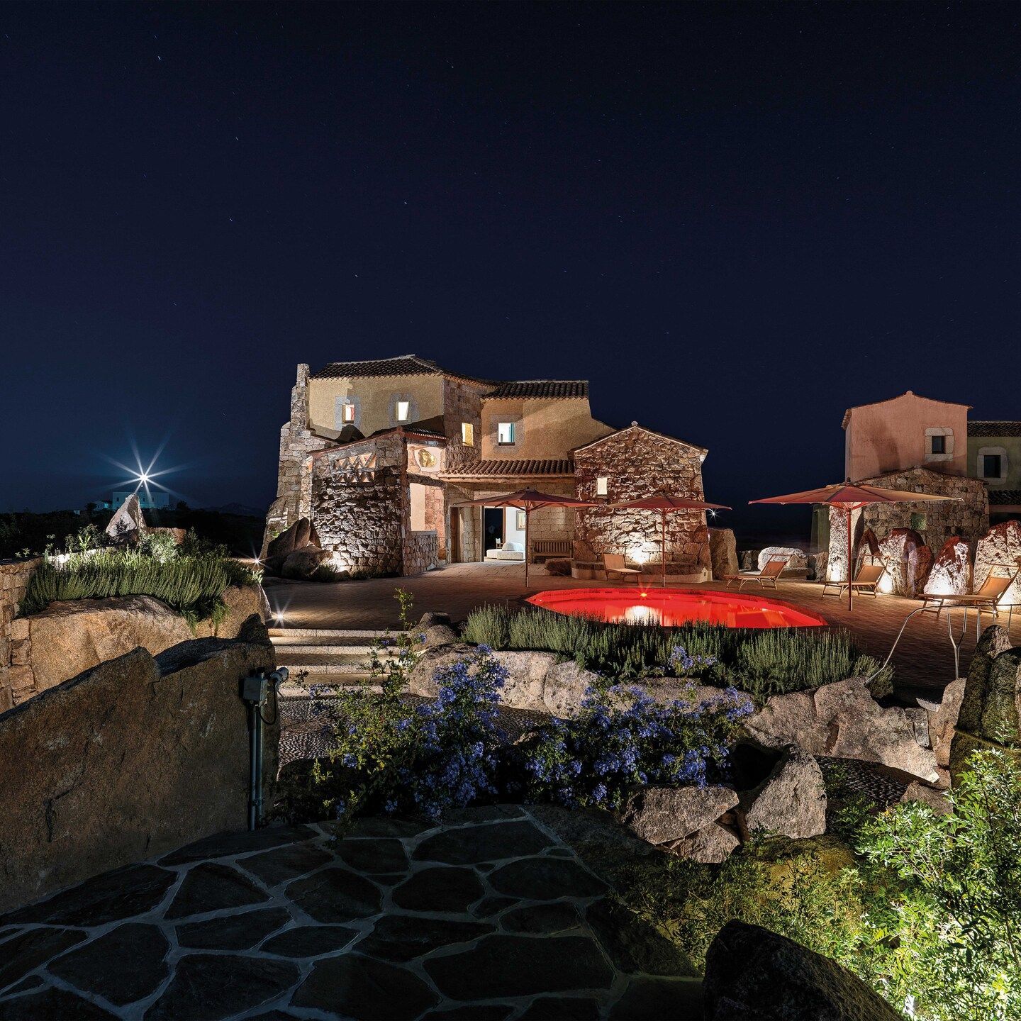  Vue nocturne de la villa il faro qui souligne l'amour de la nature et de la pierre granitique de la Sardaigne de Cou&euml;l, qui a trouv&eacute; son inclination la plus spectaculaire dans la relation avec le paysage. 