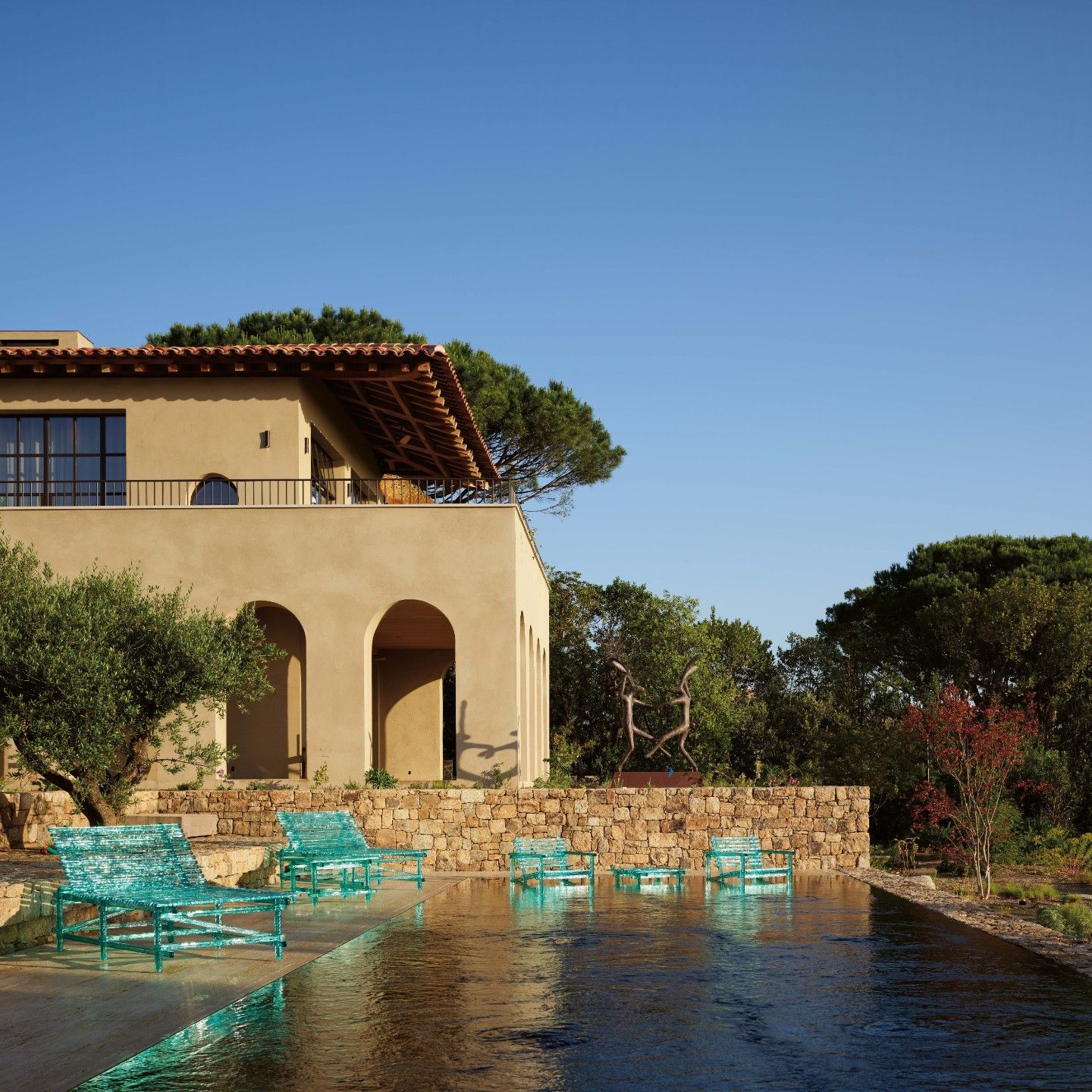  Sunbeds, tables and armchairs from the outdoor collection reflect the sunlight and colours of the pool. 